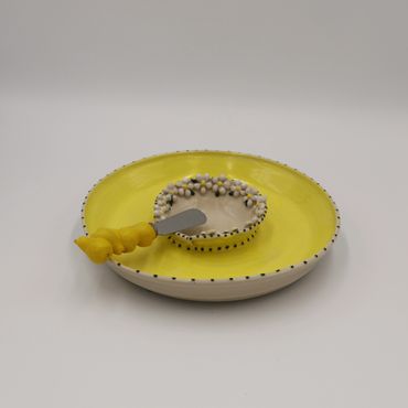 A yellow and white ceramic plate with a small bowl and a matching spreader.