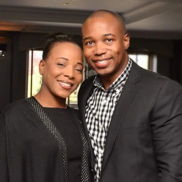 Smiling couple posing together indoors, dressed smartly.