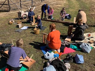 children practicing knife skills using fire wood
