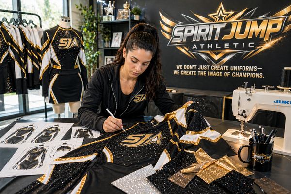 A designer customizes a glittery cheerleading uniform at Spirit Jump Athletic.