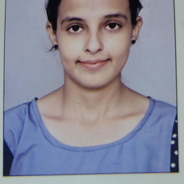 Smiling woman in blue top against plain background.