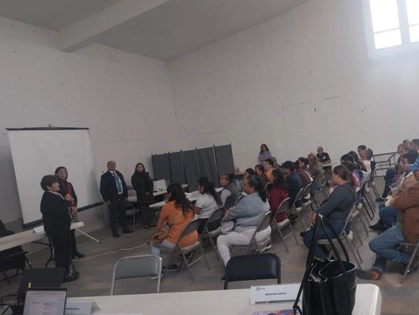 Reunión o capacitación en un aula grande con varias personas sentadas.