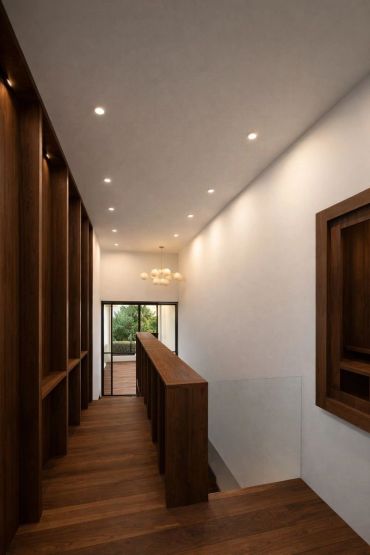 Pasillo moderno con madera y luz cálida.