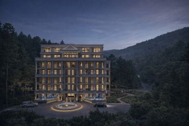 Hotel iluminado en un paisaje montañoso durante el atardecer.