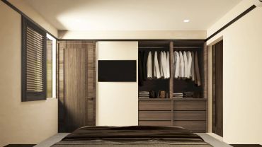 Dormitorio moderno con armario empotrado y ropa blanca.