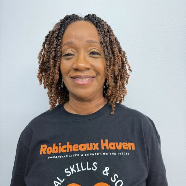 A woman smiling wearing a Robicheaux Haven shirt.