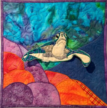 Turtle swimming over reef tiny quilt.