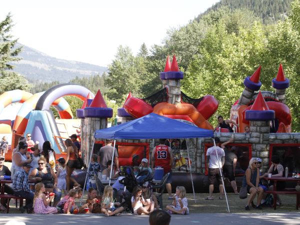 Children and adults enjoying an outdoor inflatable playground.