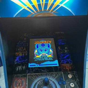 Arcade machine showing the game Journey.