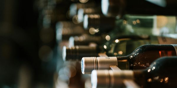 Close-up of wine bottles stacked horizontally in a cellar or rack.