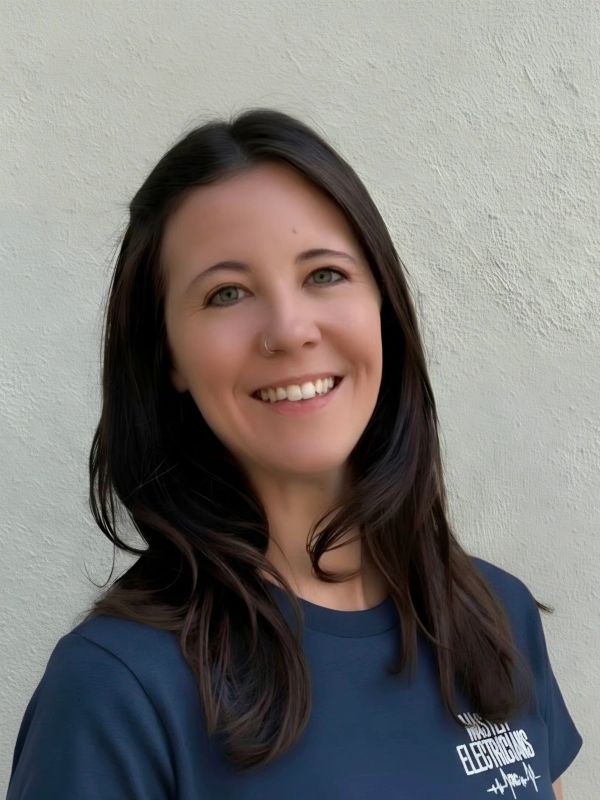 Smiling woman with long dark hair and a nose ring.