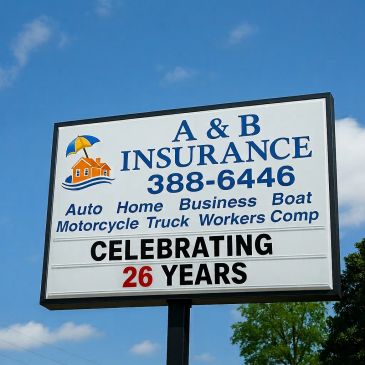Street sign mentioning insurance coverage types and celebrating 26 years in business.