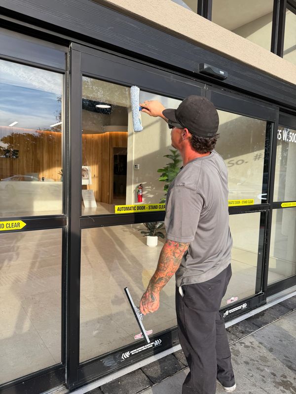 Ryno Wash Services cleaning storefront windows in Bountiful, Utah, providing cleaning for businesses