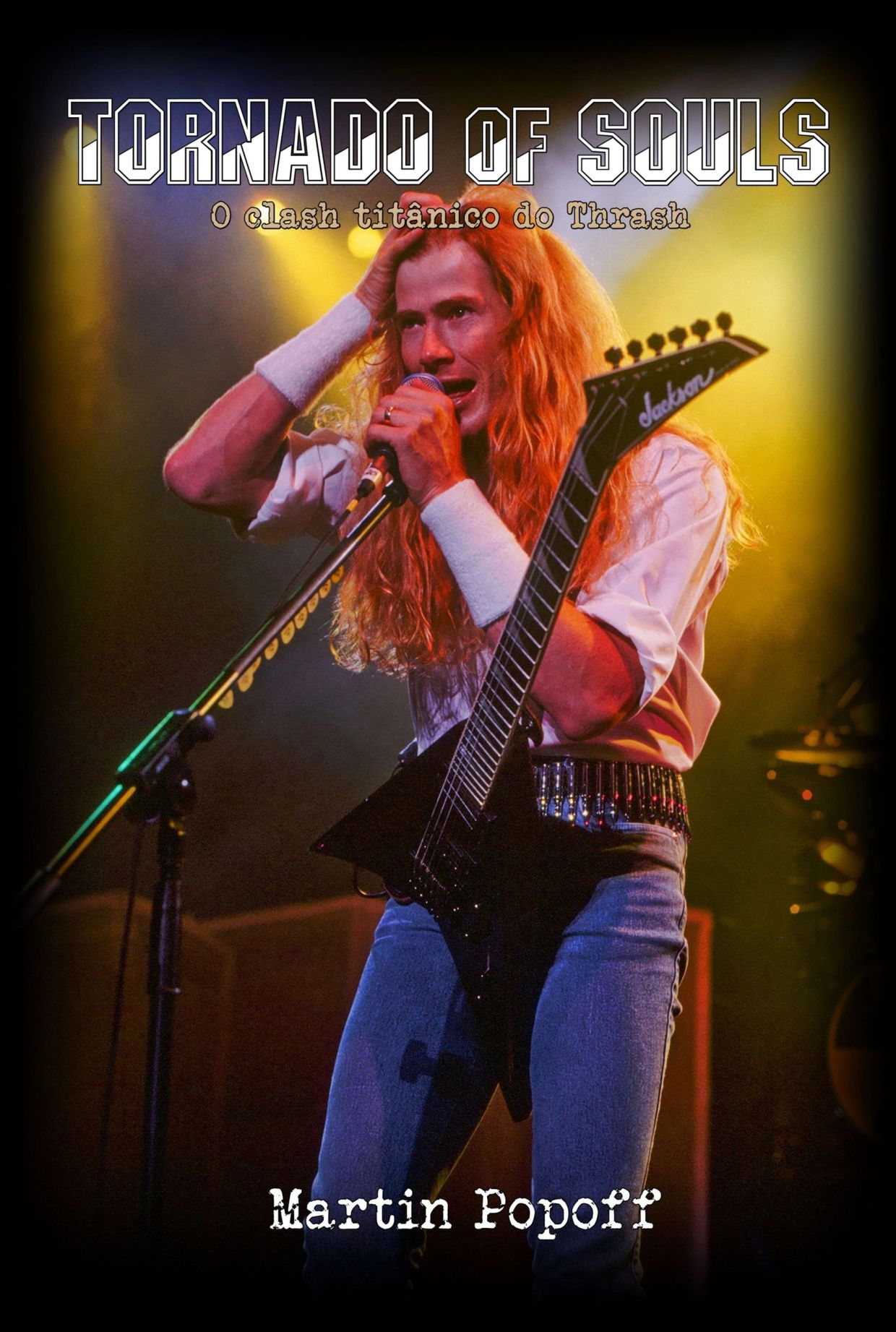 Cantor de thrash metal em palco com guitarra.