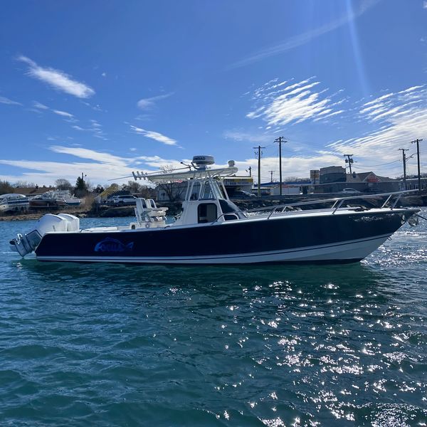 A sleek motorboat on calm water under a blue sky.