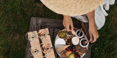 Two wooden tasting planks of sparkling wine sit next to a platter of oysters & other local produce. 