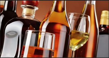 Various bottles and glasses filled with different types of alcoholic beverages.
