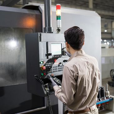 Technician operating a control panel in a manufacturing facility.