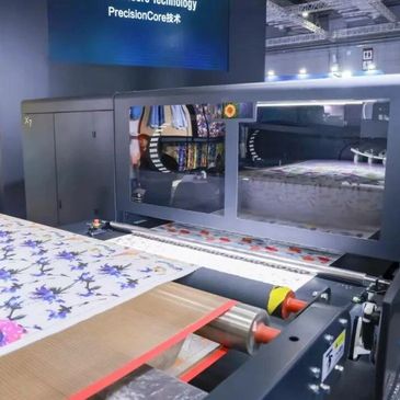 Industrial fabric printer producing floral textile patterns.