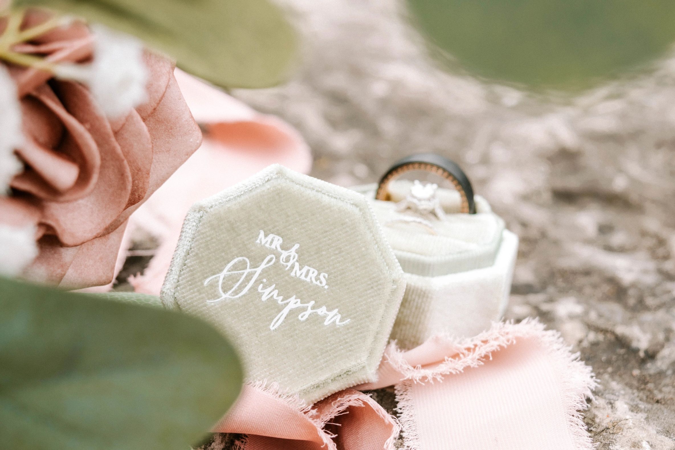 Elegant wedding ring box with "Mr &amp; Mrs Simpson" inscription and soft pink rose.