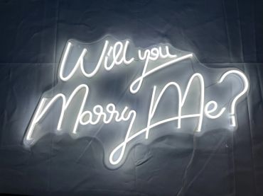 Neon sign glowing with the words 'Will you Marry Me?'