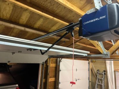 Garage door opener mechanism installed on a wooden ceiling.