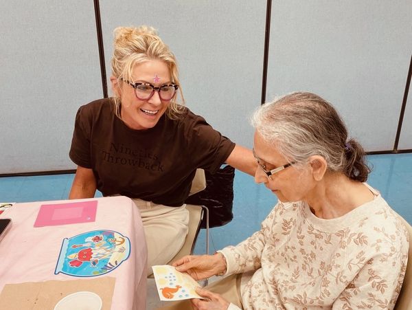 Two women sharing a joyful moment looking at a card.