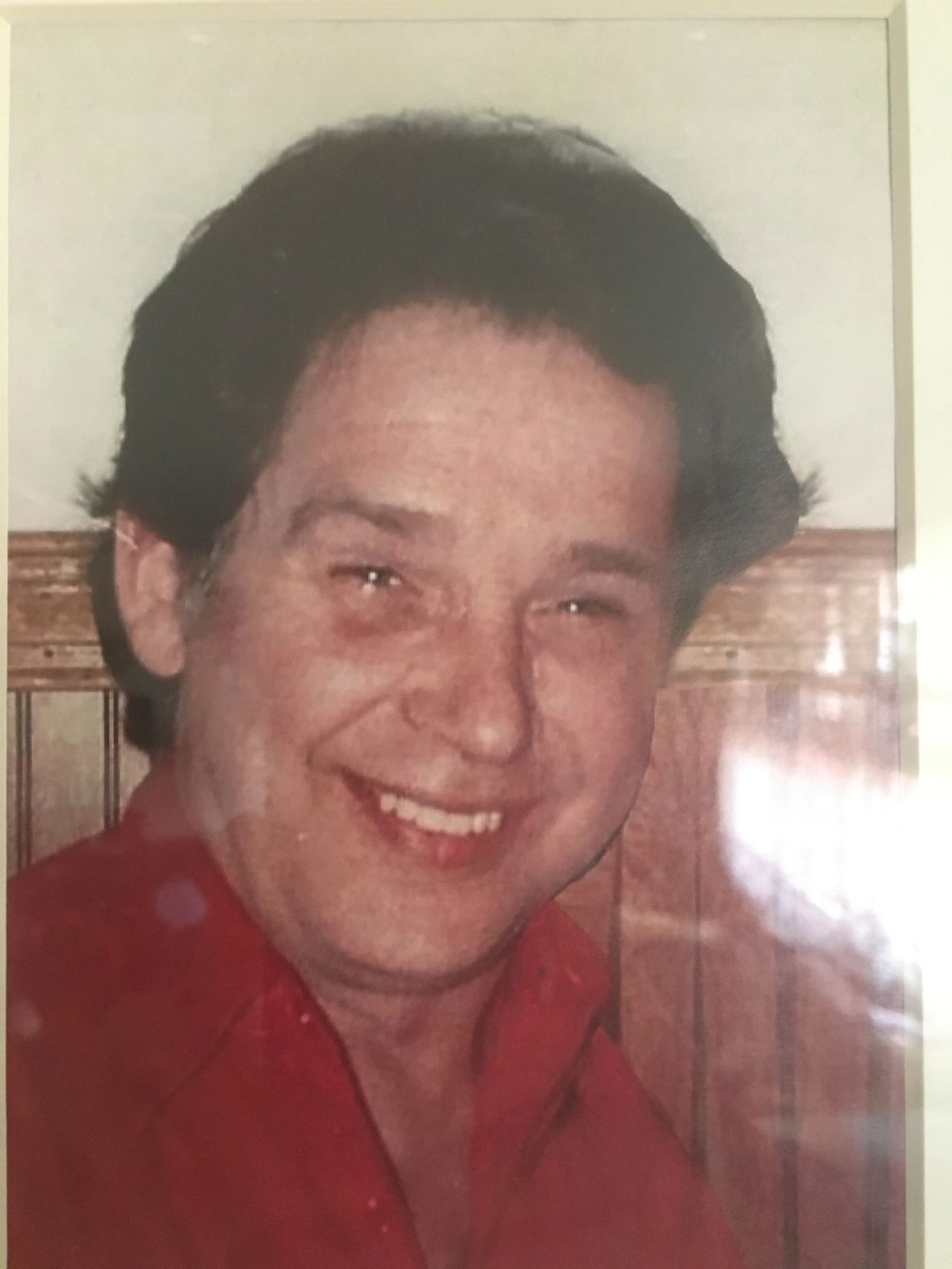 Smiling man in a red shirt.