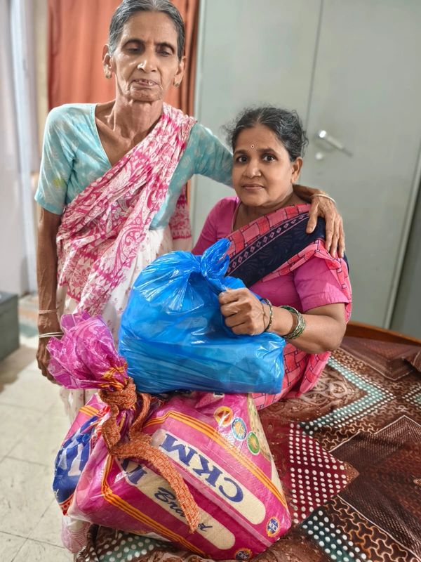 Two women with bags of supplies, showing care and support.
