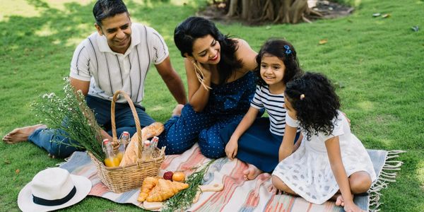 A family enjoying more time together, having a picnic in the park.