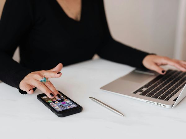 Answering guest inquiries on a laptop and a phone.