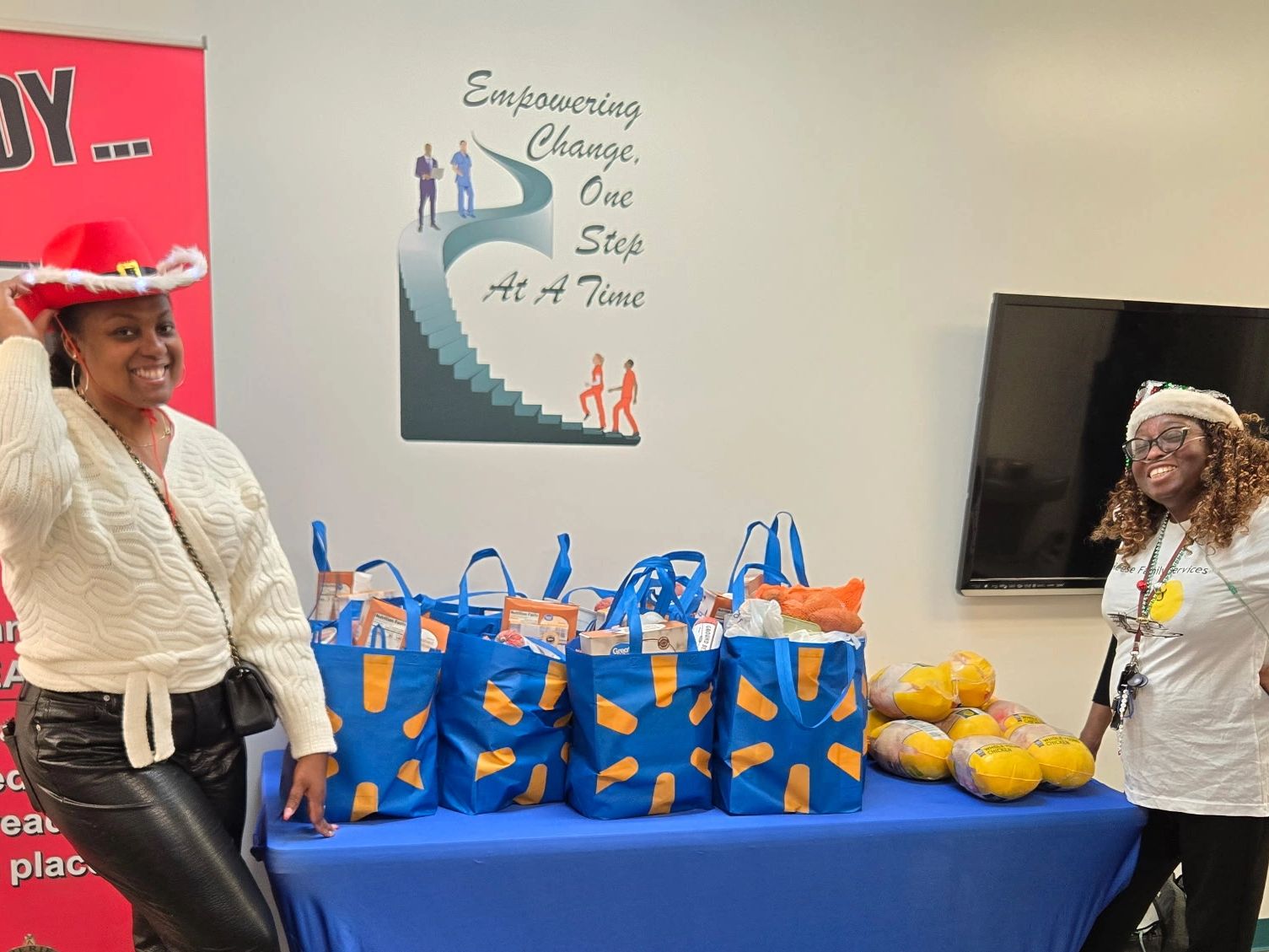 Two women smiling with bags of groceries and turkeys.