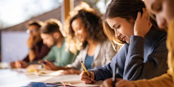 Students focused on writing and studying in a classroom setting.