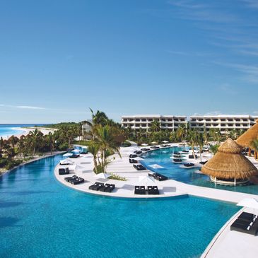 Exactly Travel showcases AM Secrets resort Riviera Maya beach resort and pool lounge chairs couples 