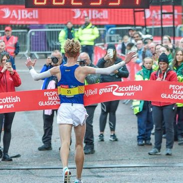 Runner crosses the finish line at the Great Scottish Run with a time of 29:54.