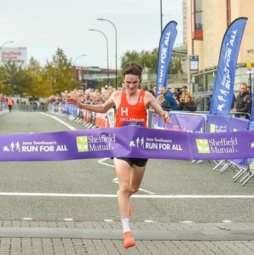 Runner crosses the finish line at Sheffield's Jane Tomlinson's Run For All event.