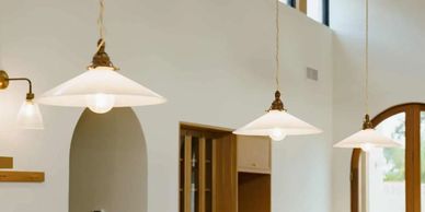 Three white pendant lights hanging in a modern interior space.