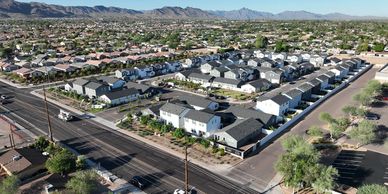 A suburban neighborhood with rows of houses and a backdrop of mountains.