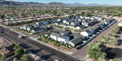 A suburban neighborhood with rows of houses and a backdrop of mountains.