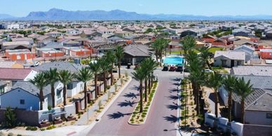 A suburban neighborhood with palm trees and distant mountains.
