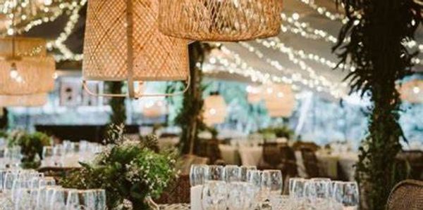 Elegant wedding reception setup with string lights and rustic decor.