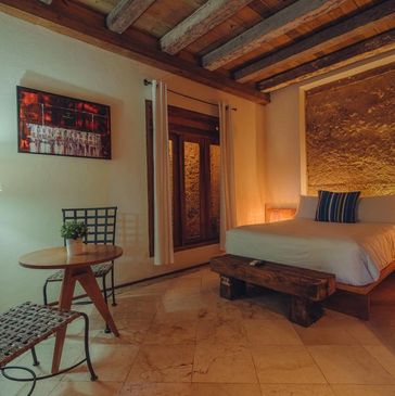 Cozy rustic bedroom with wooden beams and warm lighting.