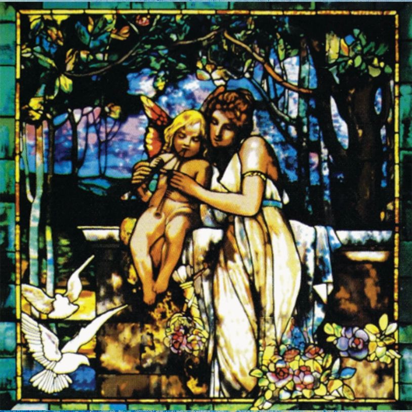 Stained glass showing a woman teaching a cherub to play a flute in a garden.