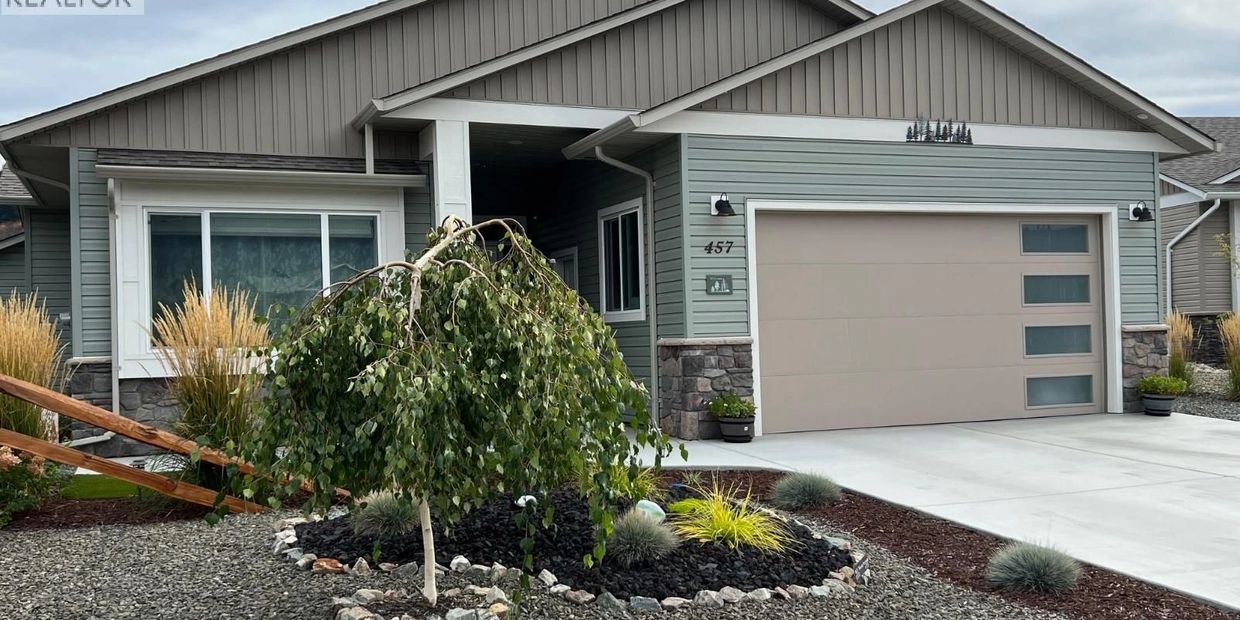 Modern gray house with stone accents and simple landscaping.