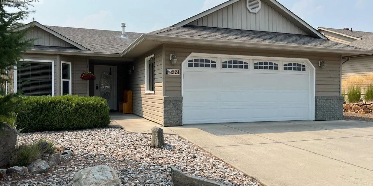 Single-story house with garage and rocky front yard.