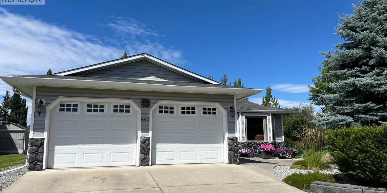 Modern house with double garage under a clear blue sky.