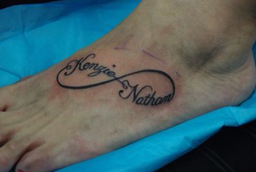 Lettering tattoo of names on a foot.