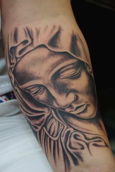 Black and grey portrait tattoo of the Virgin Mary.