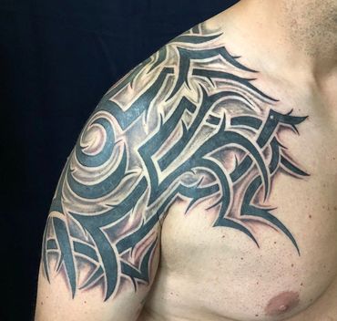 Black and grey tribal shoulder tattoo.