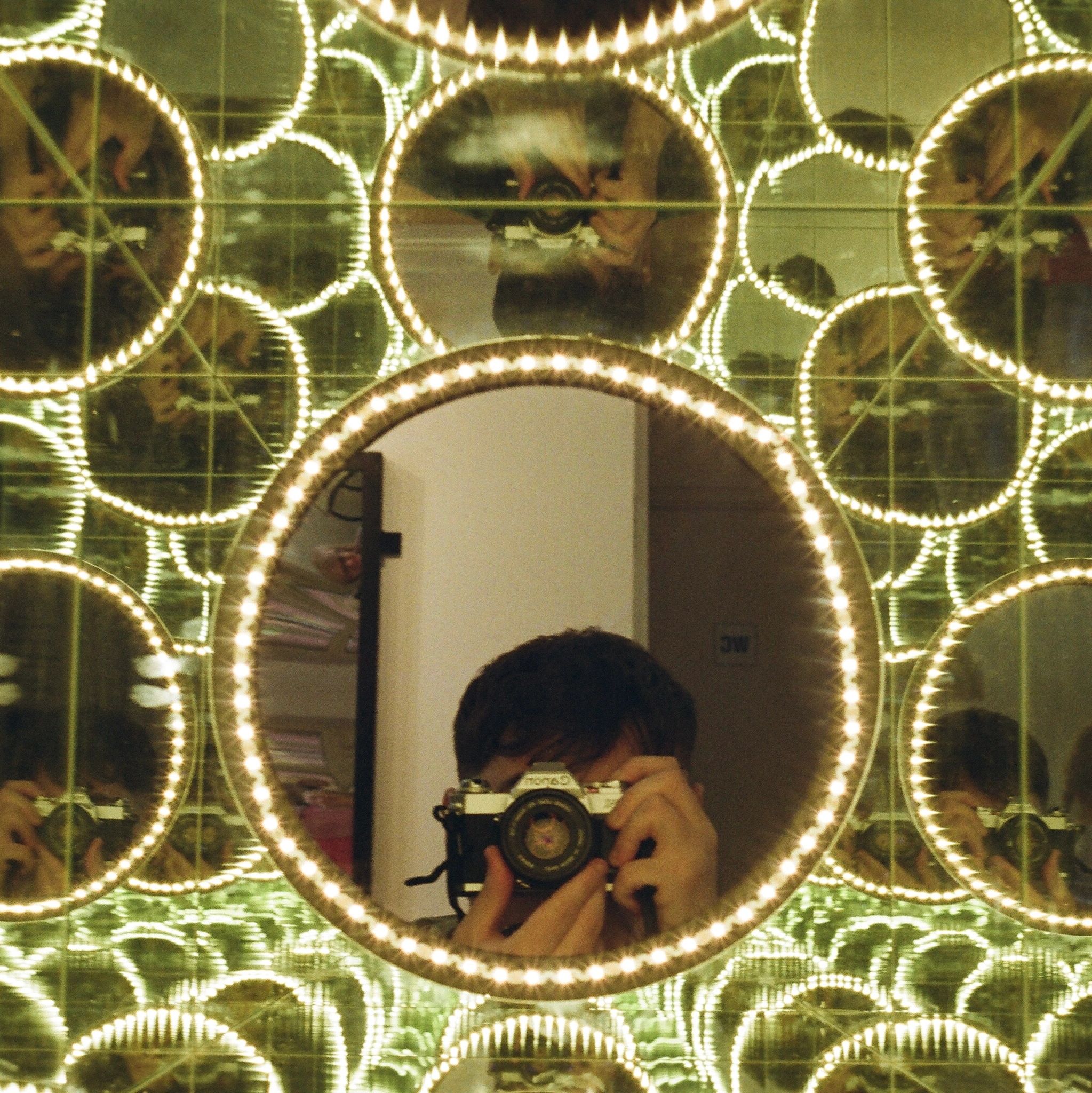 Person taking a photo in circular lights reflection.